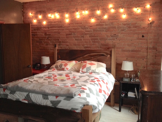 The bedroom, with freshly exposed brick and a gorgeous custom bed frame Dave built as their wedding present