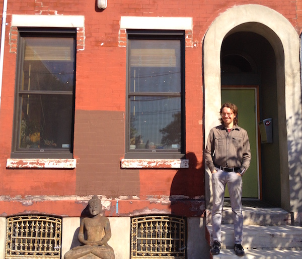 Jayme Guokas in front of one of the three adjacent rowhomes he owns; he and his wife live in this one