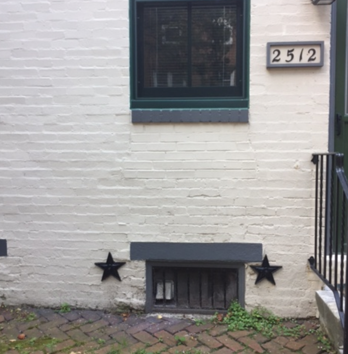 White Brick Rowhome Philadelphia with green lintels and steel starbolts for structural support