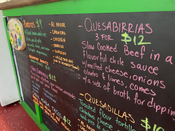 a close up of the restaurant's chalkboard menu, which lists quesabirrias, quesadillas, burritos, tacos and more. 